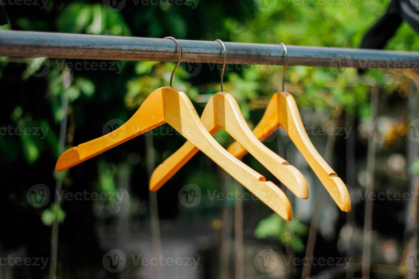 wooden clothes hanger with a natural leafy background in the garden photo