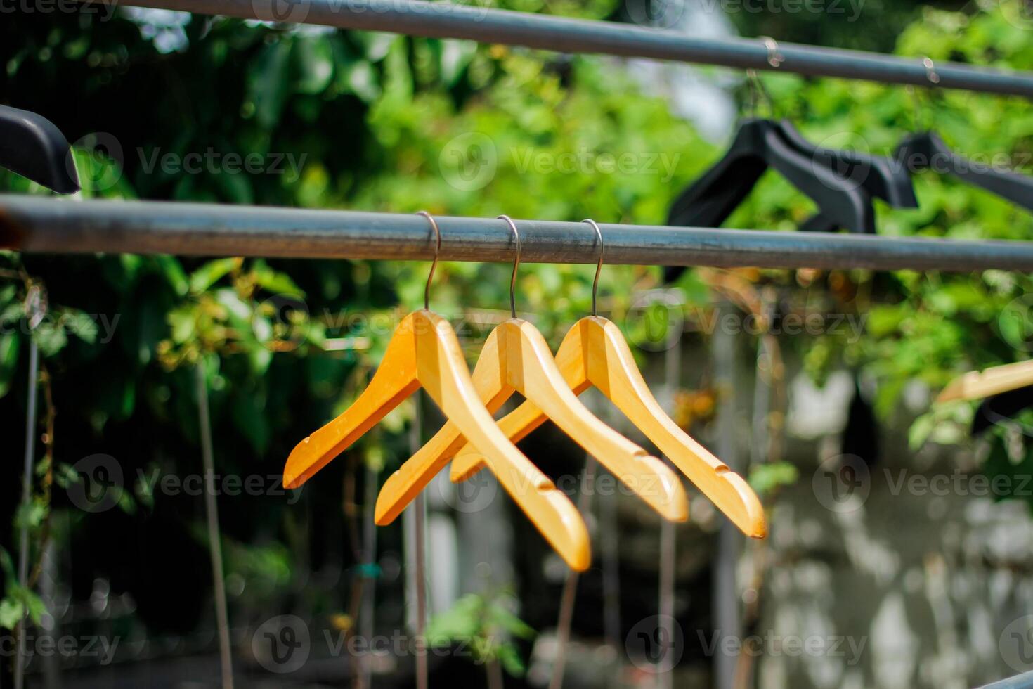 wooden clothes hanger with a natural leafy background in the garden photo