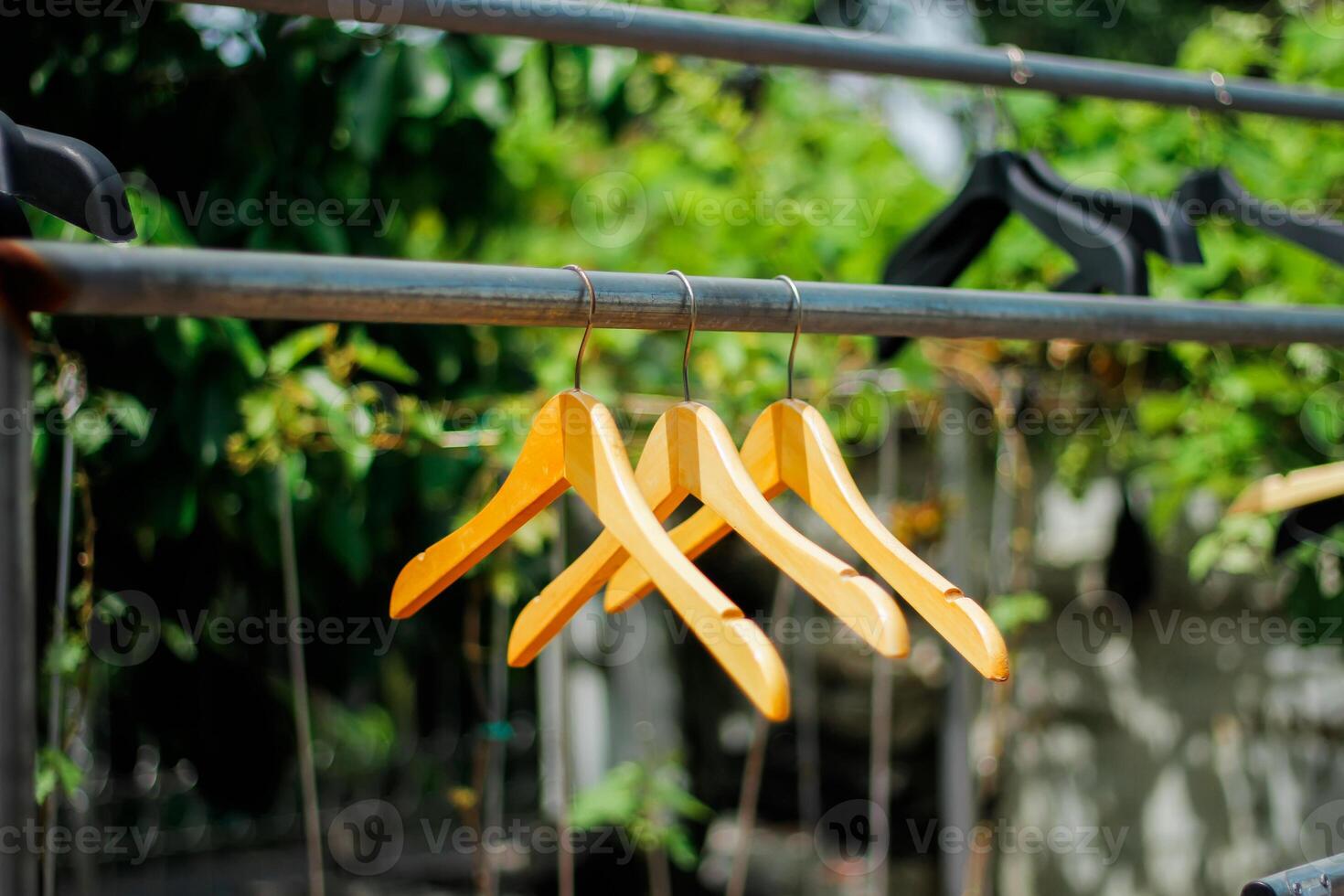 wooden clothes hanger with a natural leafy background in the garden photo