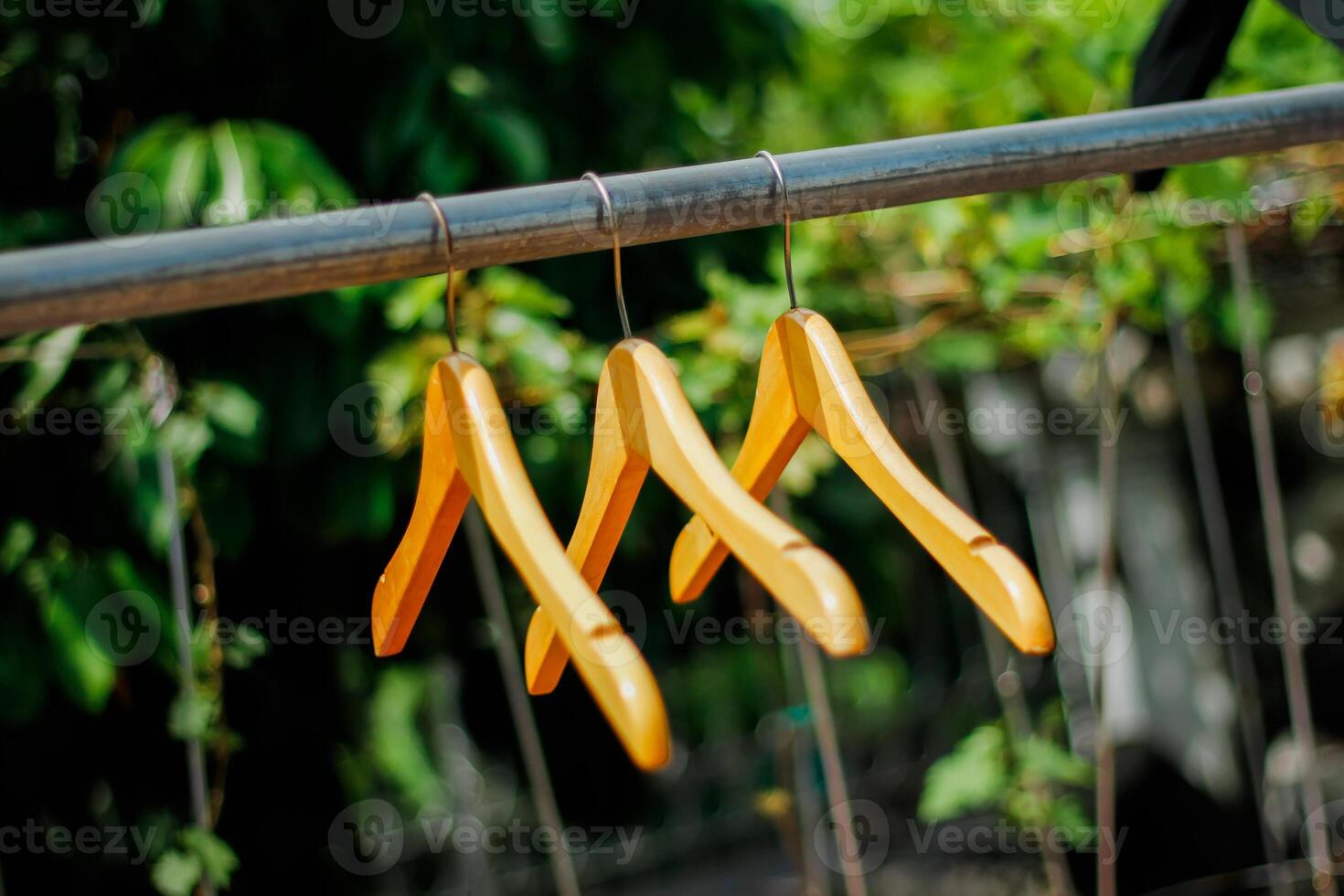 wooden clothes hanger with a natural leafy background in the garden photo