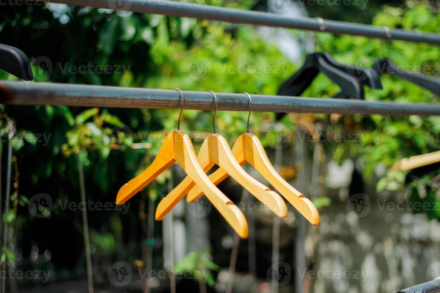 wooden clothes hanger with a natural leafy background in the garden photo