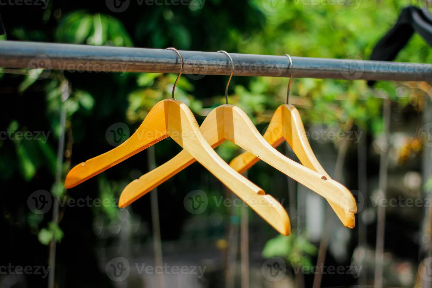 wooden clothes hanger with a natural leafy background in the garden photo