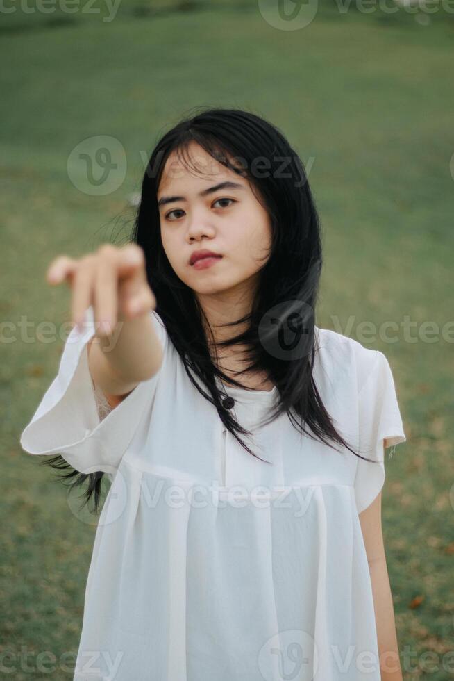 Portrait of a pretty young woman dressed in white dress holding rose flowers photo