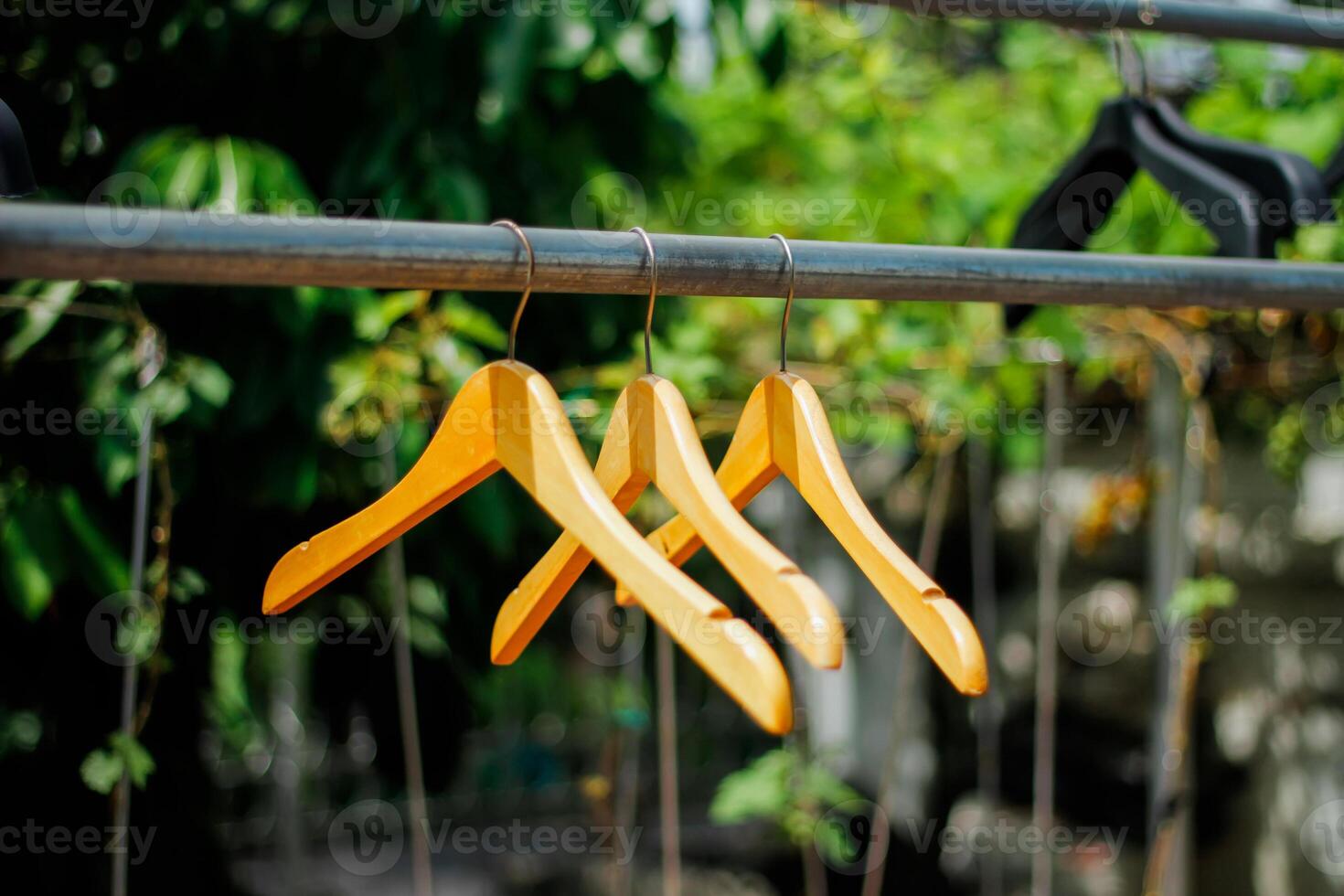 wooden clothes hanger with a natural leafy background in the garden photo