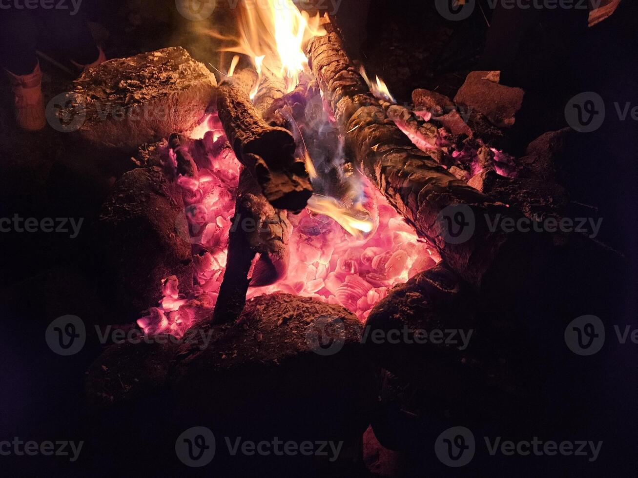 Flames of a stone pit fire at night in dark background at a campground state park in Washington State photo