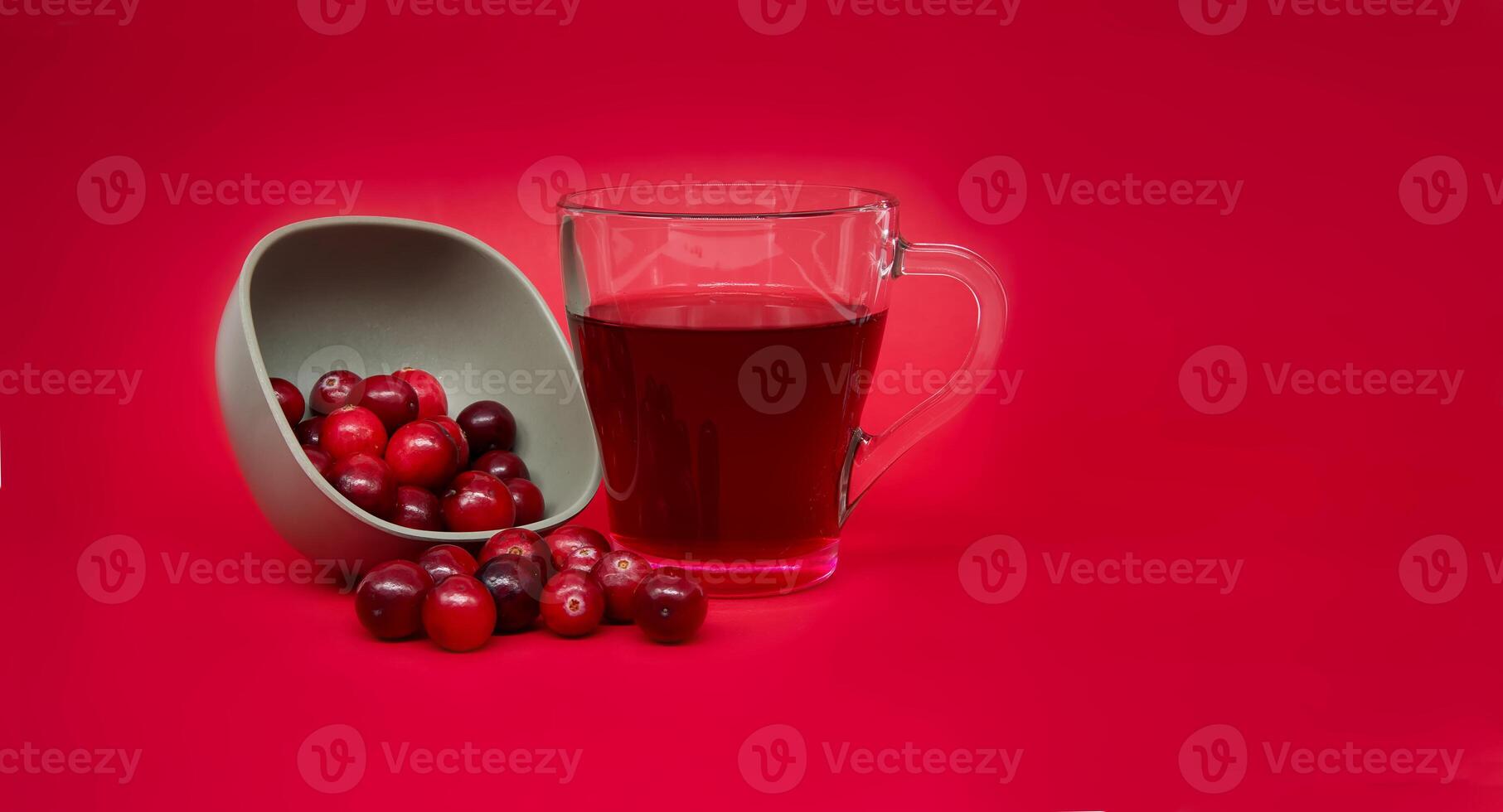 Fresh cranberries and cranberry juice against red photo