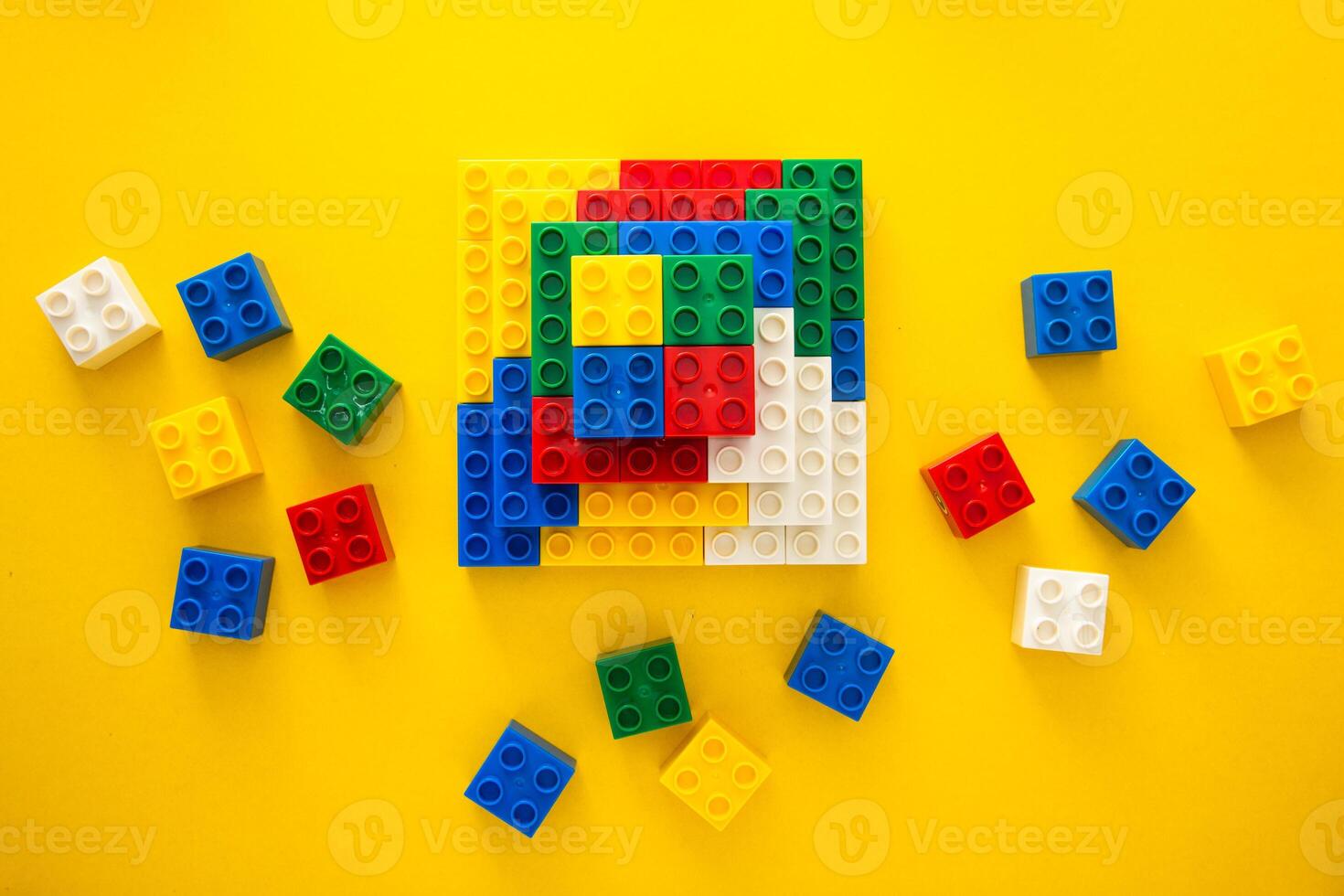 Color plastic building blocks on yellow background photo