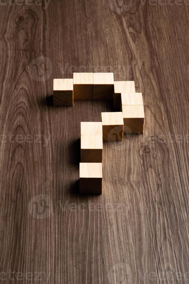 Forming bigger question mark. question mark on wooden table background photo