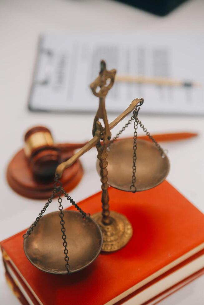 Business and lawyers discussing contract papers with brass scale on desk in office. Law, legal services, advice, justice and law concept picture with film grain effect photo