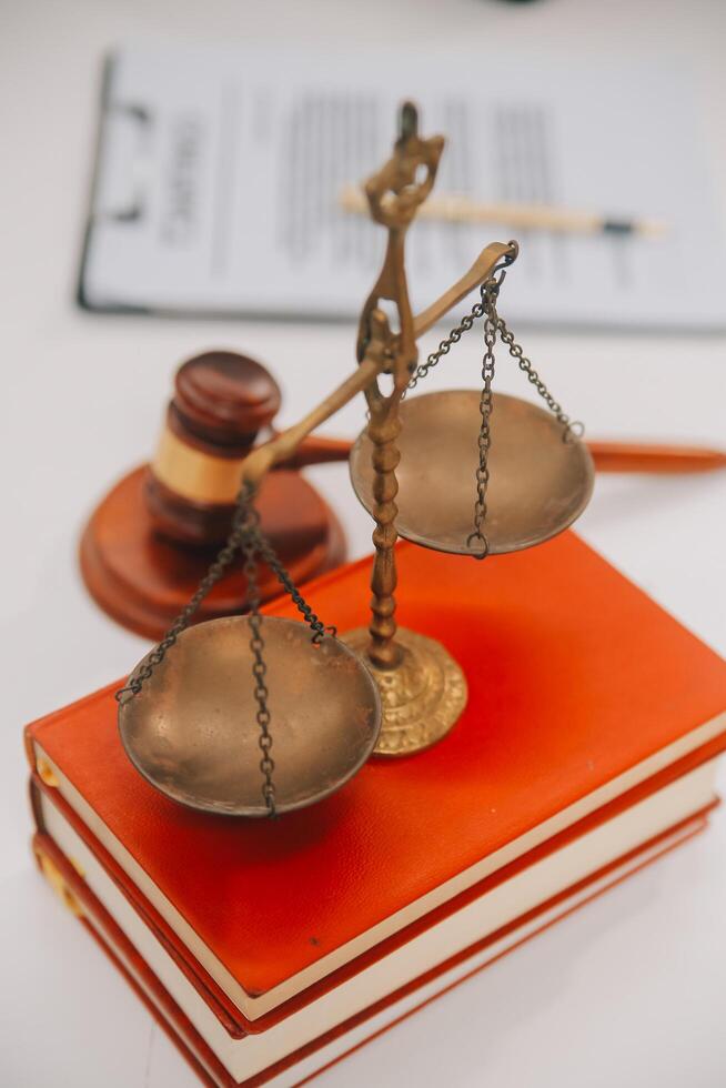 Business and lawyers discussing contract papers with brass scale on desk in office. Law, legal services, advice, justice and law concept picture with film grain effect photo