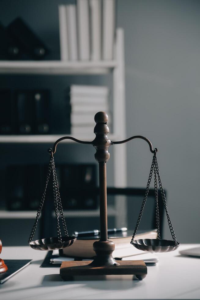 Business and lawyers discussing contract papers with brass scale on desk in office. Law, legal services, advice, justice and law concept picture with film grain effect photo