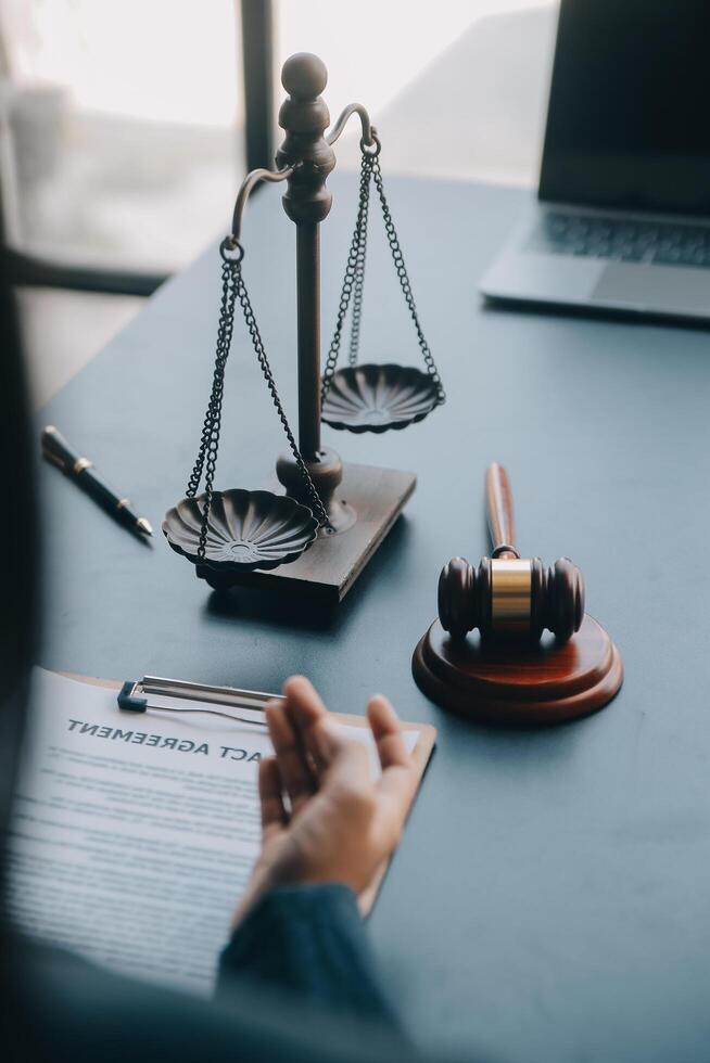 Justice and law concept.Male judge in a courtroom with the gavel, working with, computer and docking keyboard, eyeglasses, on table in morning light photo