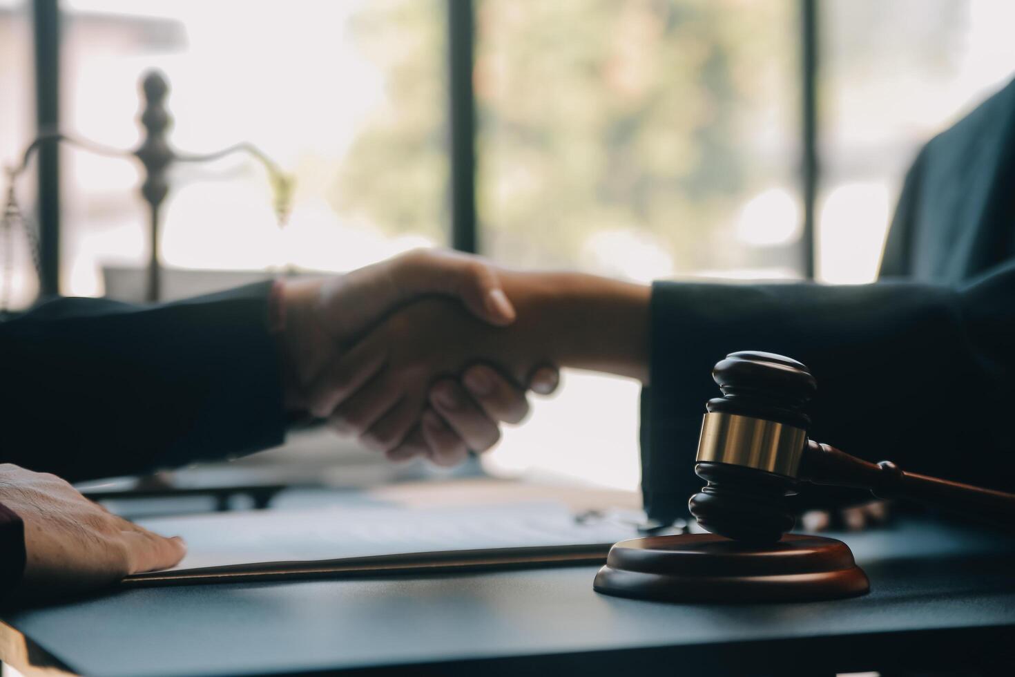 Justice and law concept.Male judge in a courtroom with the gavel, working with, computer and docking keyboard, eyeglasses, on table in morning light photo