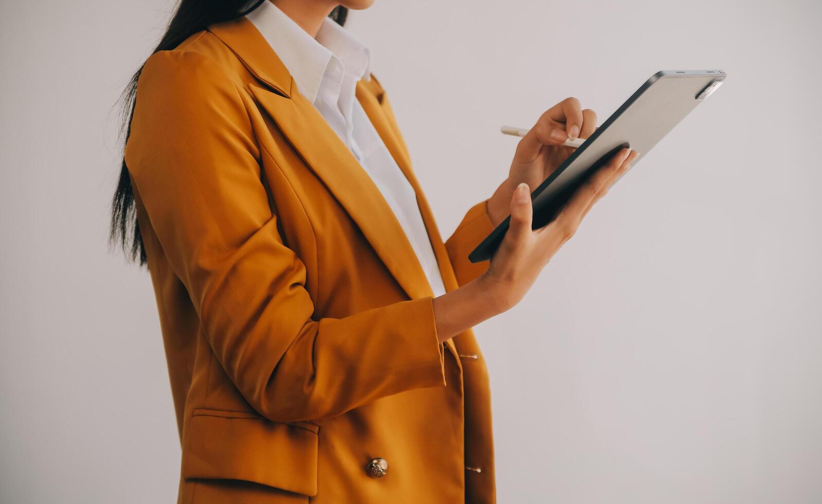 Portrait of Young Asian woman hand freelancer is working her job on computer tablet in modern office. Doing accounting analysis report real estate investment data, Financial and tax systems concept. photo