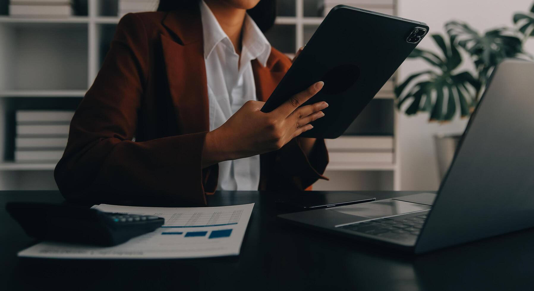 mujer de negocios asiática que usa calculadora y computadora portátil para hacer finanzas matemáticas en un escritorio de oficina, impuestos, informes, contabilidad, estadísticas y concepto de investigación analítica foto