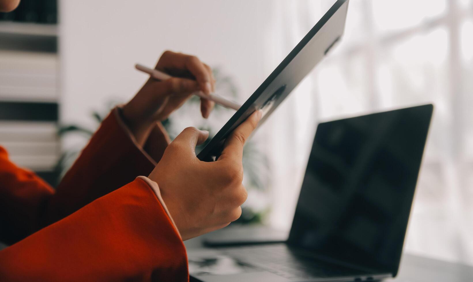 Asian Business woman using calculator and laptop for doing math finance on an office desk, tax, report, accounting, statistics, and analytical research concept photo