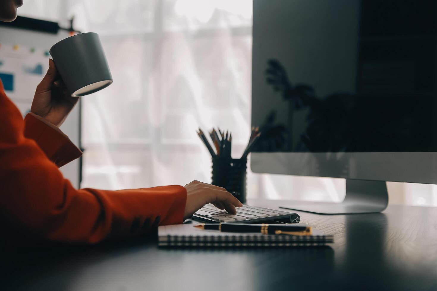 Asian Business woman using calculator and laptop for doing math finance on an office desk, tax, report, accounting, statistics, and analytical research concept photo