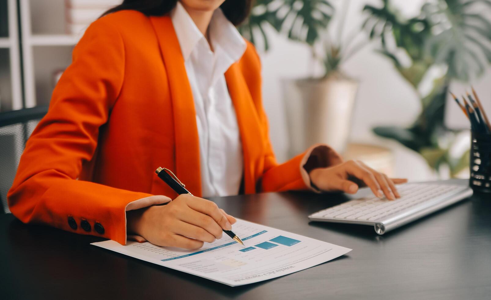 Asian Business woman using calculator and laptop for doing math finance on an office desk, tax, report, accounting, statistics, and analytical research concept photo