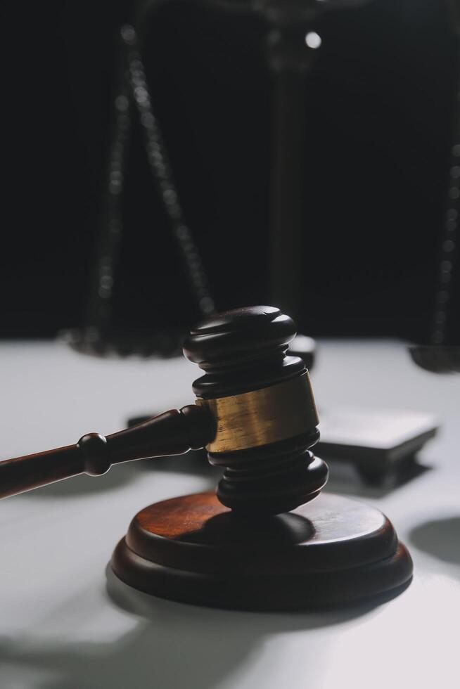 image of judge's hammer, scales lady of justice, law book, laptop computer and contract documents with pen concept of law and justice. photo