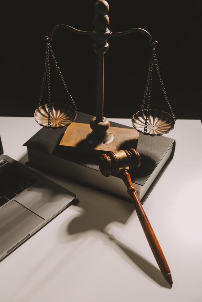 image of judge's hammer, scales lady of justice, law book, laptop computer and contract documents with pen concept of law and justice. photo