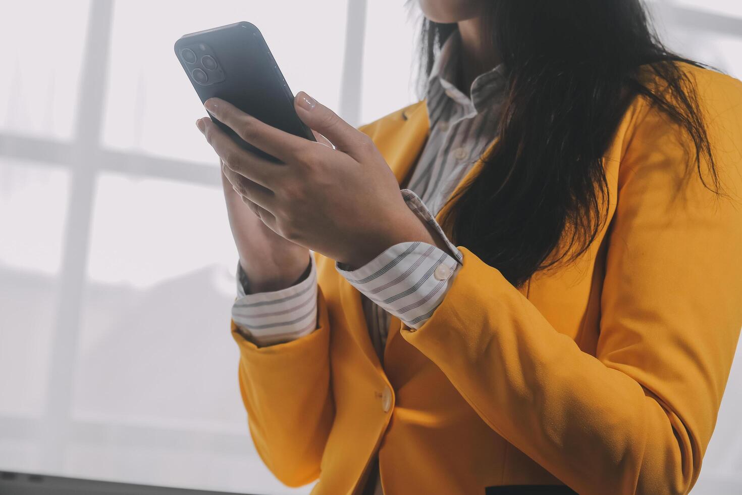 negocio mujer utilizando móvil teléfono durante trabajando en ordenador portátil computadora, surf el Internet, buscando negocio datos a moderno oficina. asiático mujer de negocios en línea trabajando en computadora a lugar de trabajo foto