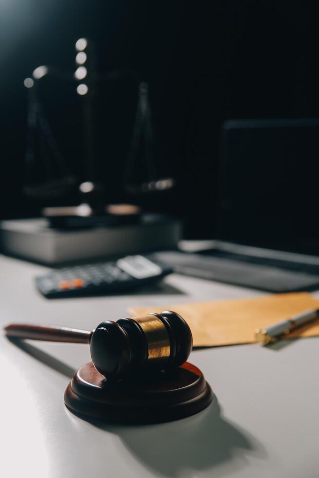 image of judge's hammer, scales lady of justice, law book, laptop computer and contract documents with pen concept of law and justice. photo