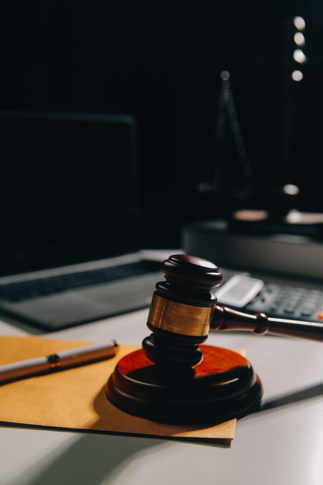 image of judge's hammer, scales lady of justice, law book, laptop computer and contract documents with pen concept of law and justice. photo