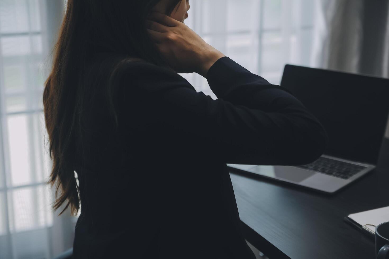 Asian Businesswoman Using laptop computer and working at office with calculator document on desk, doing planning analyzing the financial report, business plan investment, finance analysis concept. photo