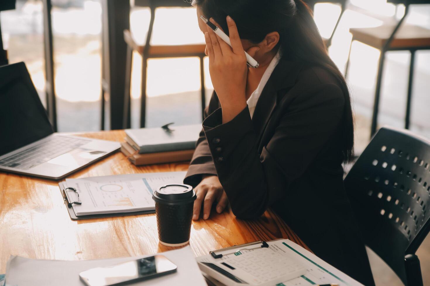Asian women are stressed while working on laptop, Tired asian businesswoman with headache at office, feeling sick at work, copy space photo