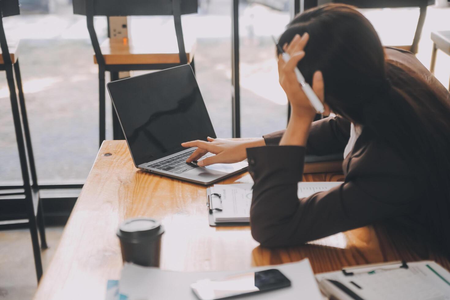 Asian women are stressed while working on laptop, Tired asian businesswoman with headache at office, feeling sick at work, copy space photo