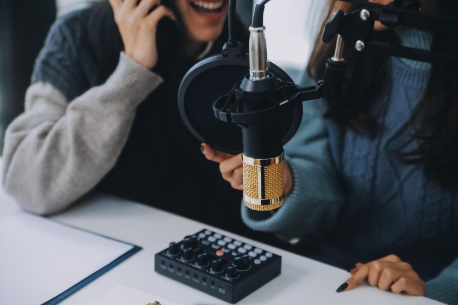 Woman recording a podcast on her laptop computer with headphones and a microscope. Female podcaster making audio podcast from her home studio. photo