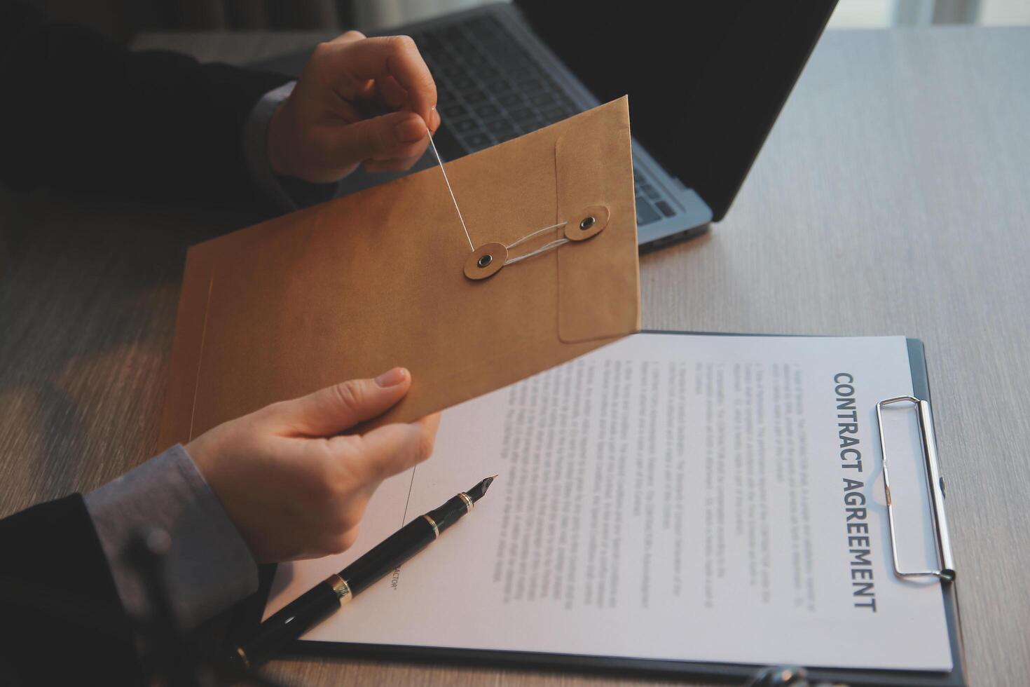 Business and lawyers discussing contract papers with brass scale on desk in office. Law, legal services, advice, justice and law concept picture with film grain effect photo