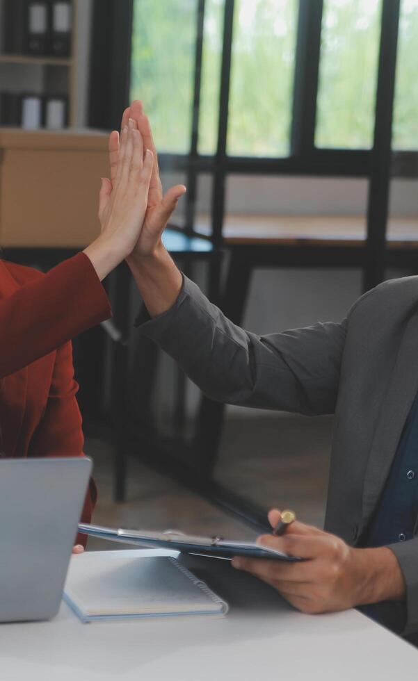 grupo de jóvenes empresarios asiáticos del equipo de negocios creativos compañeros de trabajo en el cargo felices de tener éxito en el trabajo en equipo de la asociación celebrando el logro y el concepto de éxito. foto