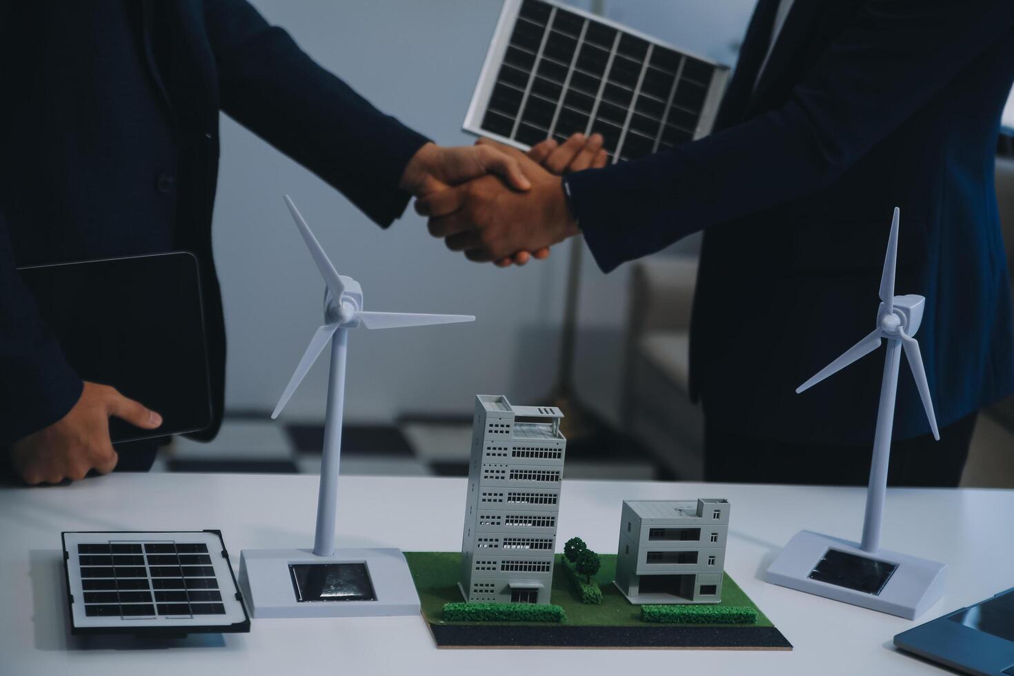 dos joven ingenieros pericia en solar célula instalación reuniones y discusión en el trabajo. planificación a Instalar en pc solar fotovoltaica paneles en techo parte superior en el oficina habitación con fábrica edificio plan. foto