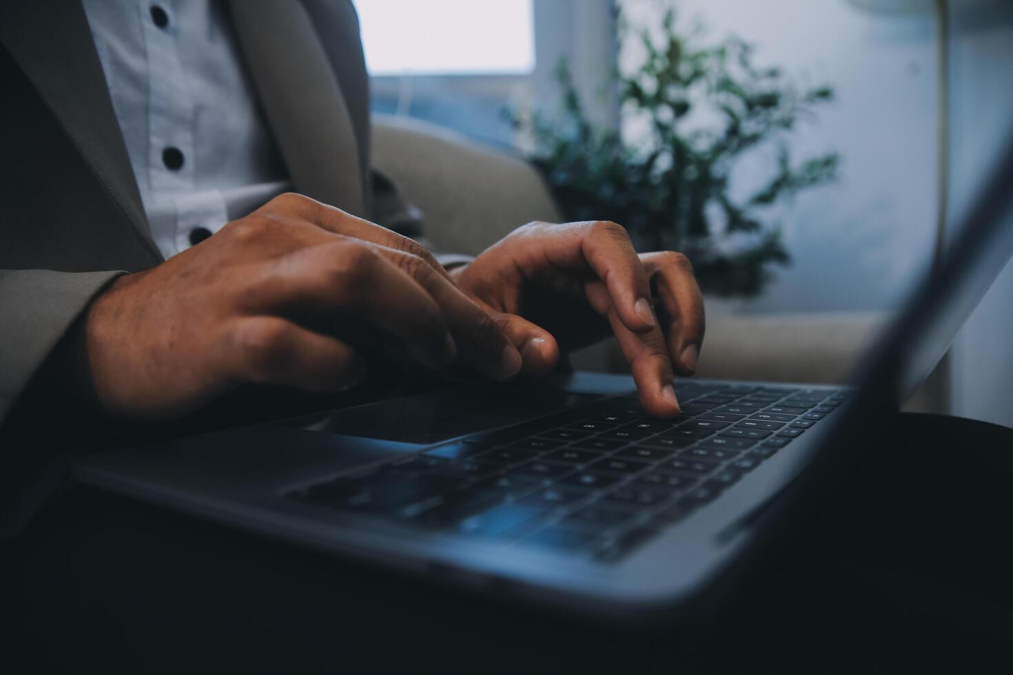 Young businessman working in office, sitting at desk, looking at laptop computer screen photo