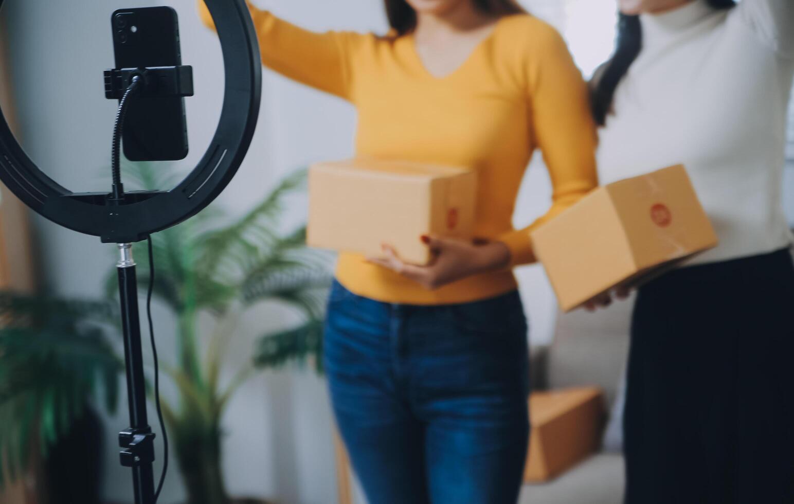 asiático mujer amigos Pareja hablar a cámara a vender el ropa a hogar. joven atractivo negocio personas hembra En Vivo transmisión y demostración ropa a cliente en en línea Al por menor a ventas a oficina Tienda foto