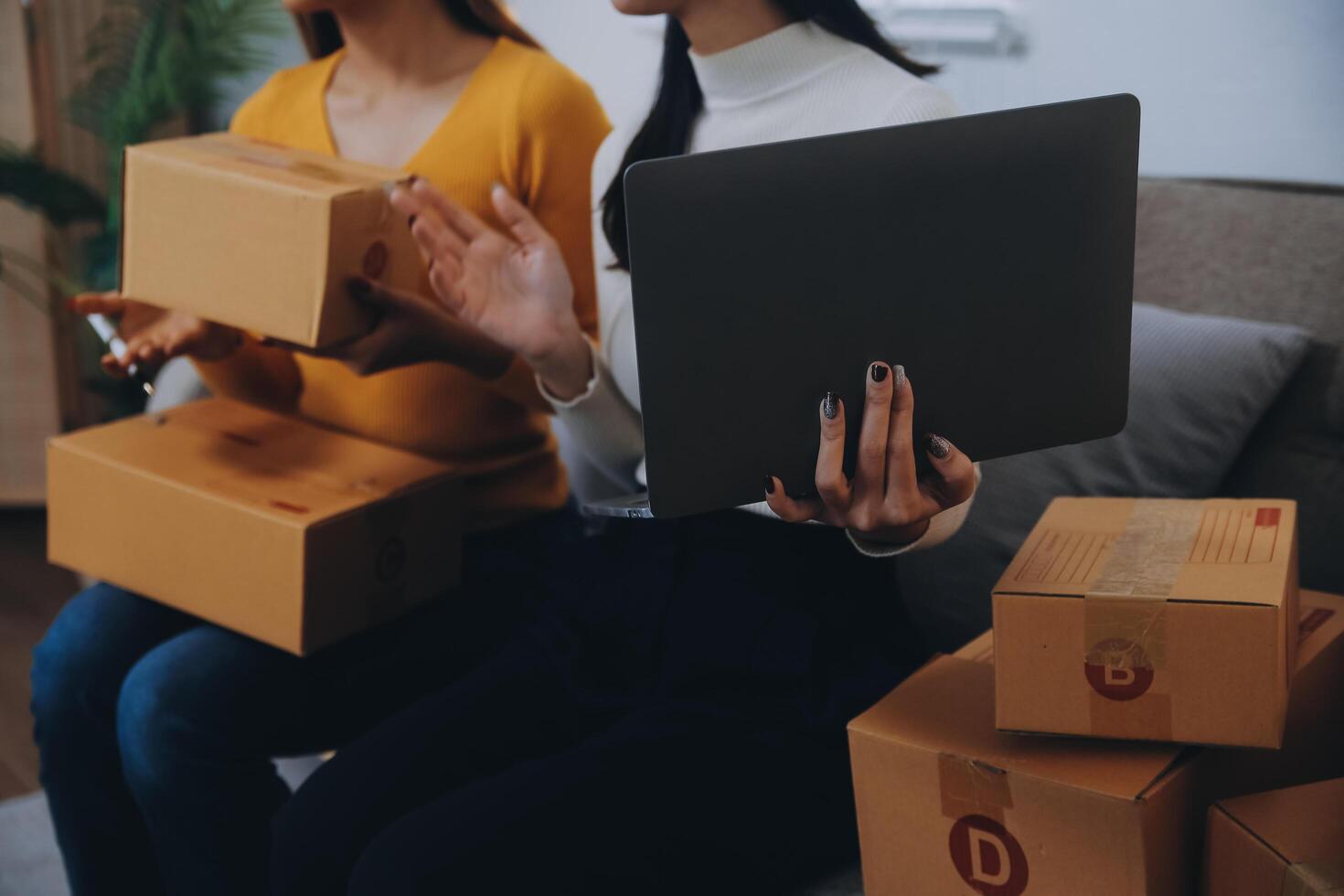 Asian SME business women use laptop computer checking customer order online shipping boxes at home. Starting Small business entrepreneur SME freelance. Online business, Work at home concept. photo