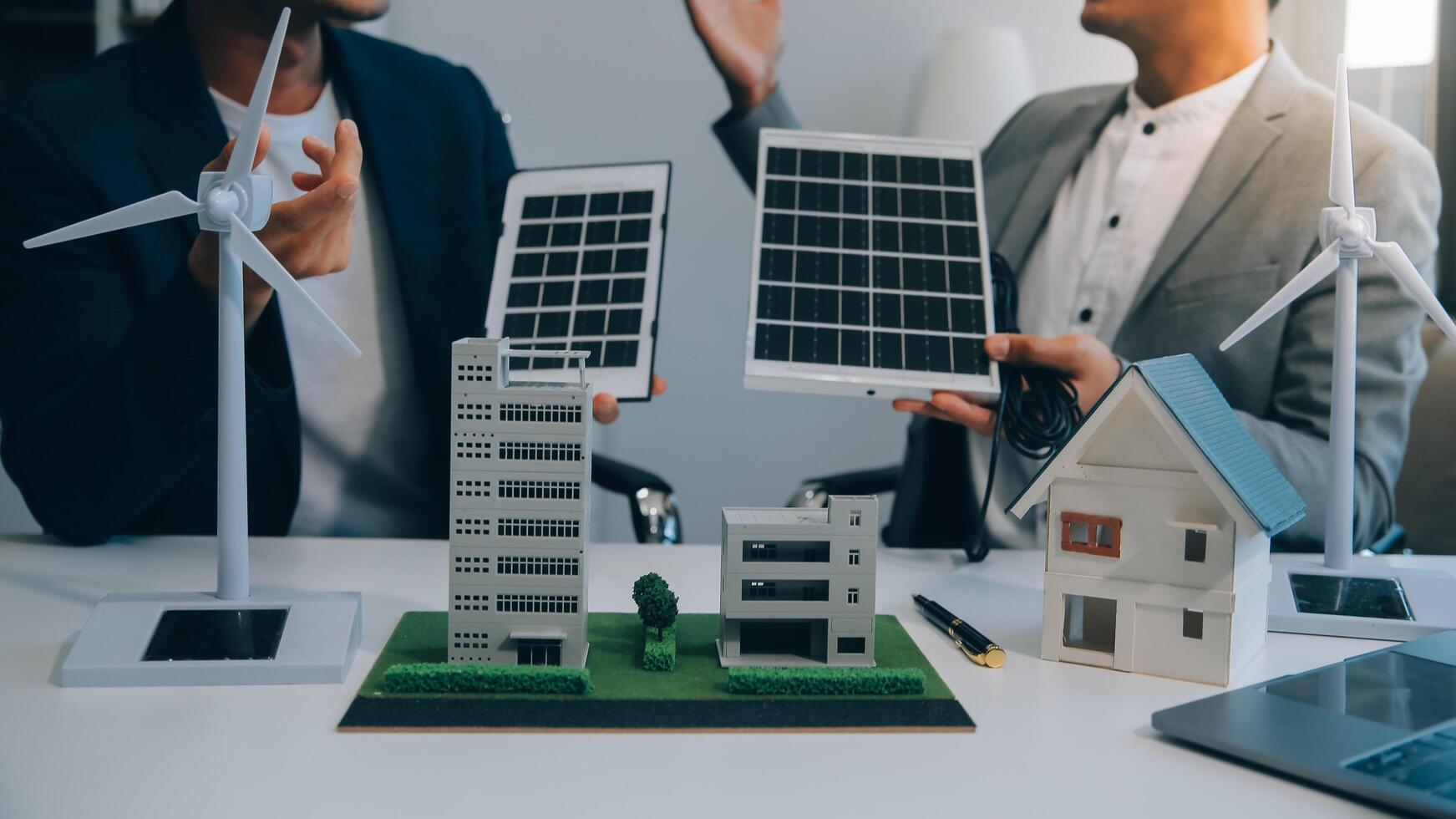 Two Young Engineers Expertise in Solar Cell Installation Meetings and Discussion in The Job. Planning to Install Solar Photovoltaic Panels on Roof Top in The Office Room with Factory Building Plan. photo