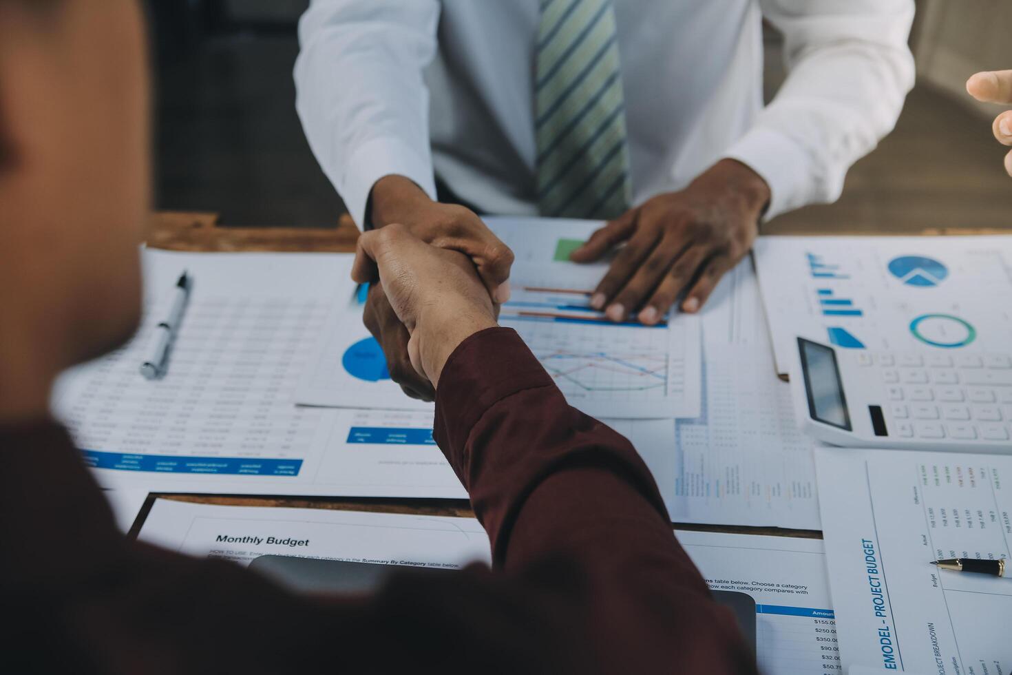 Real estate agent and customers shaking hands together celebrating finished contract after about home insurance and investment loan, handshake and successful deal. photo