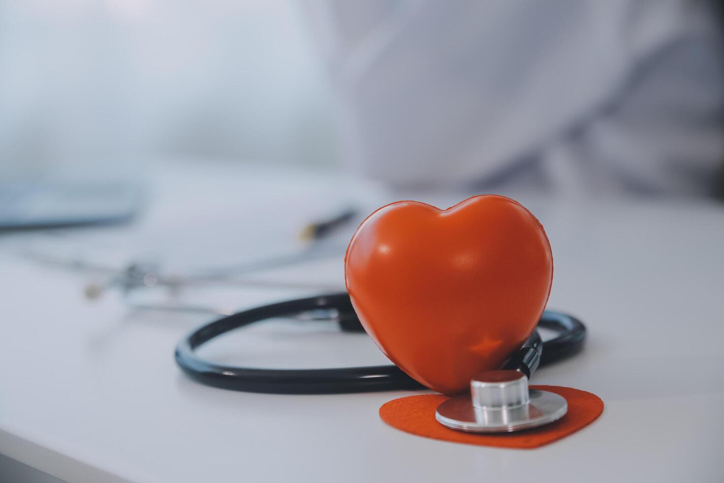 Doctor explaining heart to elderly patient. Doctor explaining the heart model. Doctors pen point to a model of the heart photo