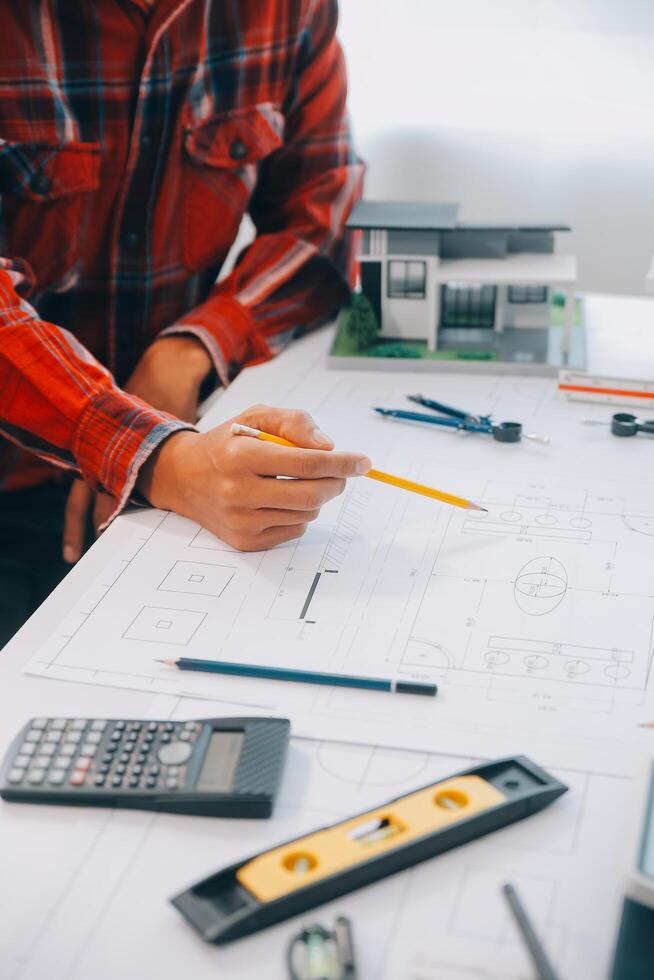 engineer people meeting working and pointing at a drawings in office for discussing. Engineering tools and construction concept. photo
