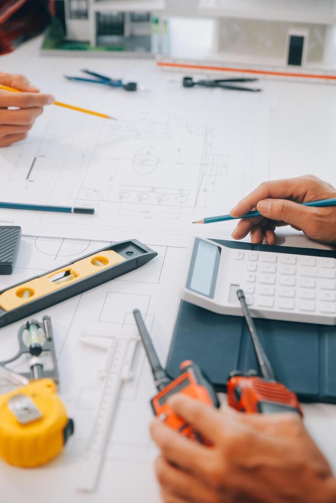 engineer people meeting working and pointing at a drawings in office for discussing. Engineering tools and construction concept. photo