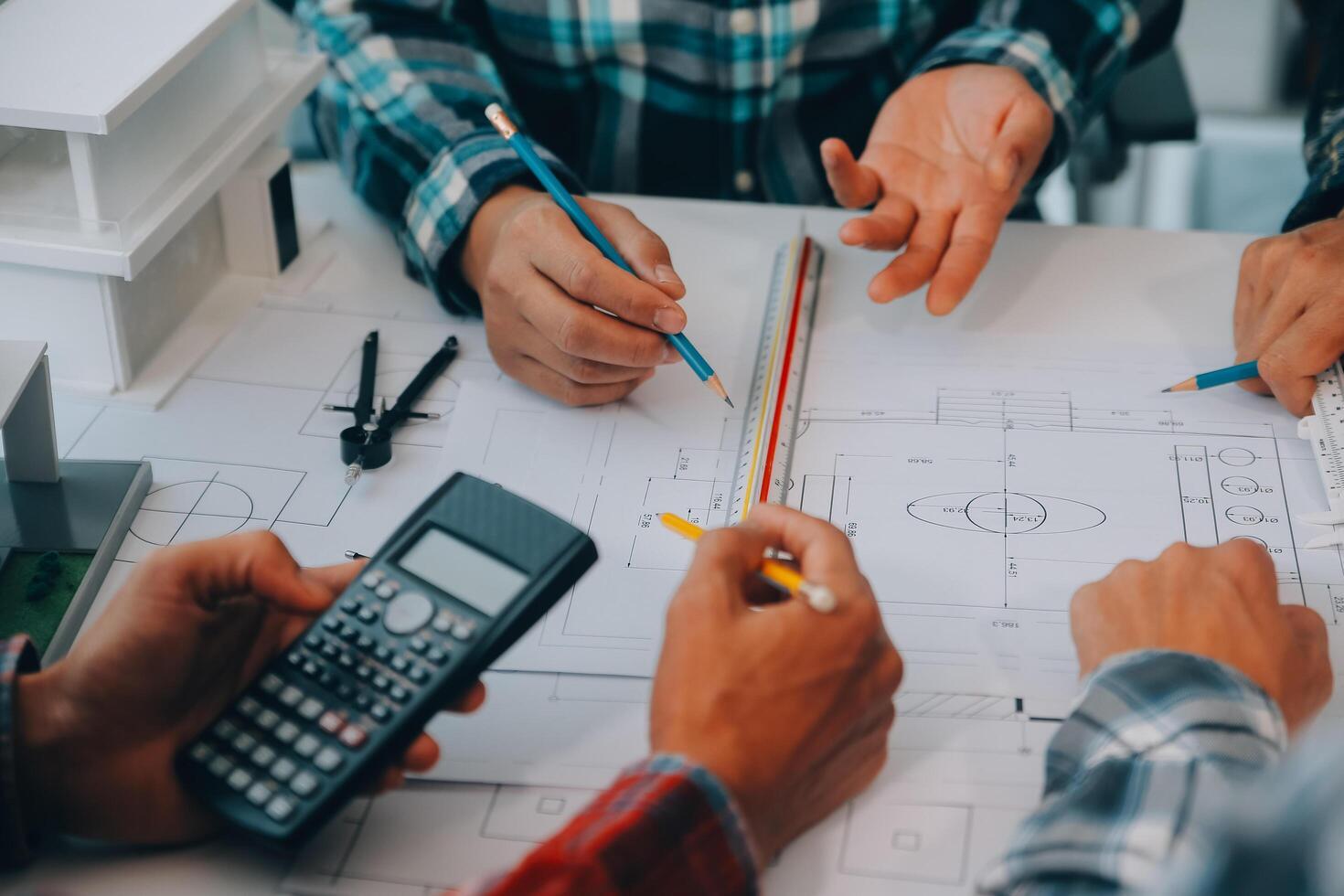 engineer people meeting working and pointing at a drawings in office for discussing. Engineering tools and construction concept. photo