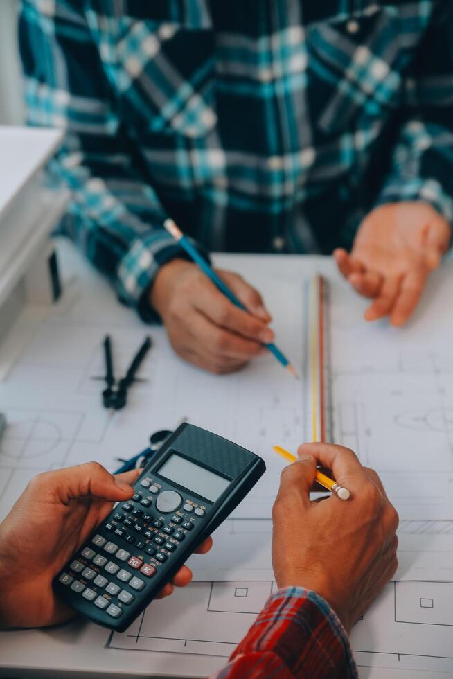 engineer people meeting working and pointing at a drawings in office for discussing. Engineering tools and construction concept. photo