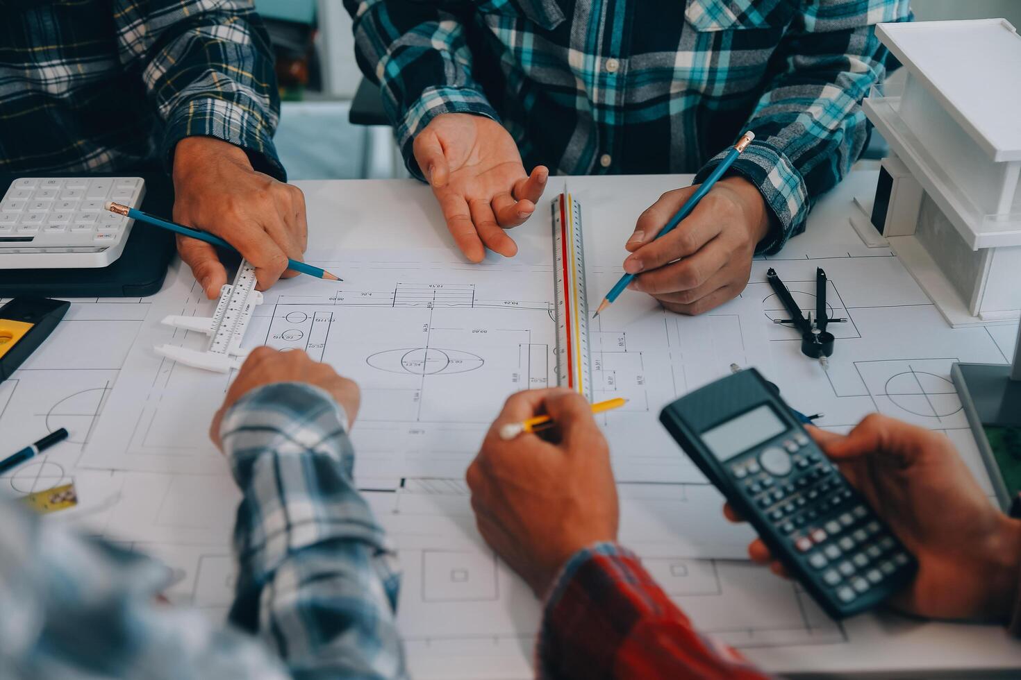 engineer people meeting working and pointing at a drawings in office for discussing. Engineering tools and construction concept. photo