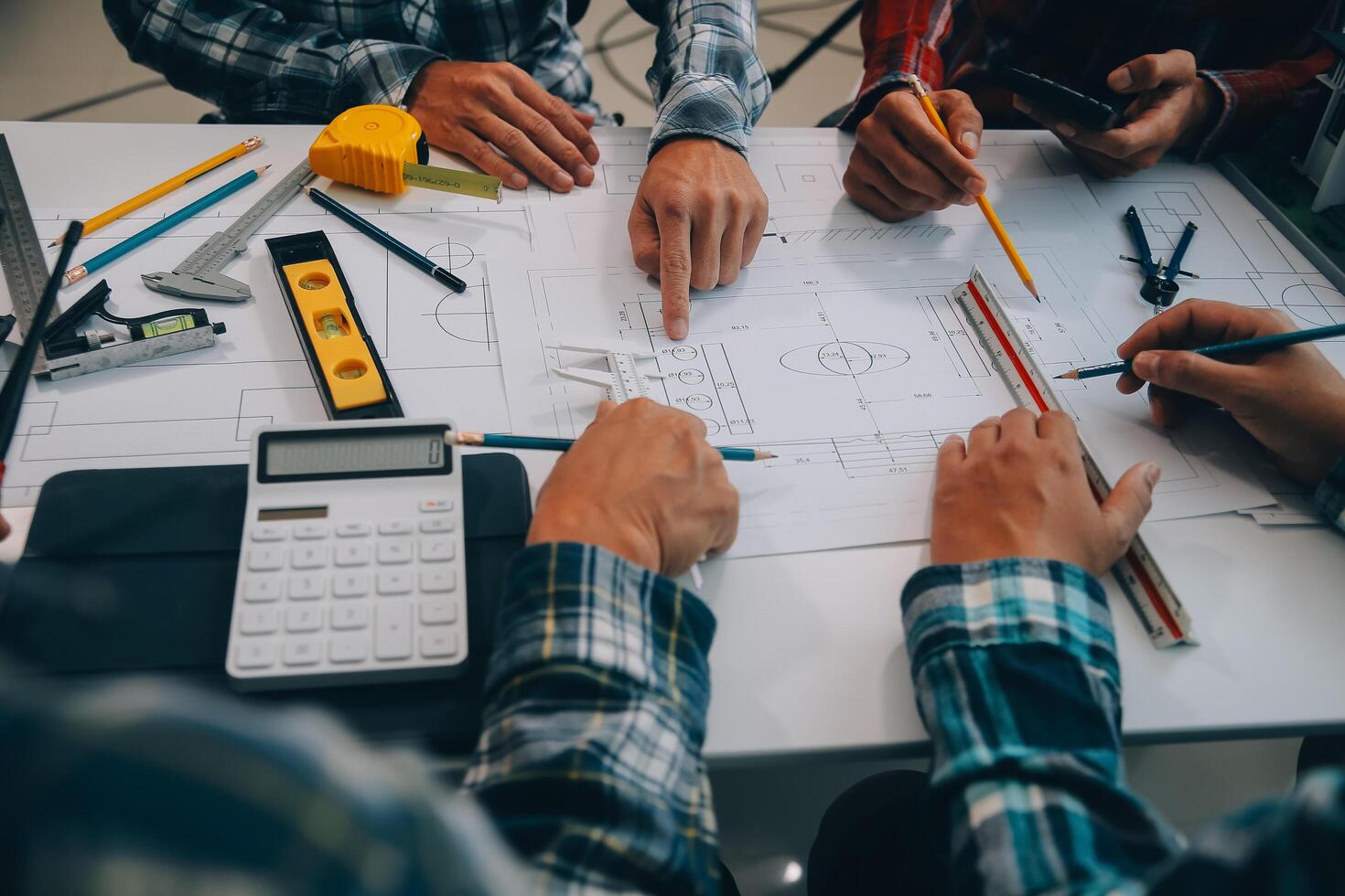 engineer people meeting working and pointing at a drawings in office for discussing. Engineering tools and construction concept. photo