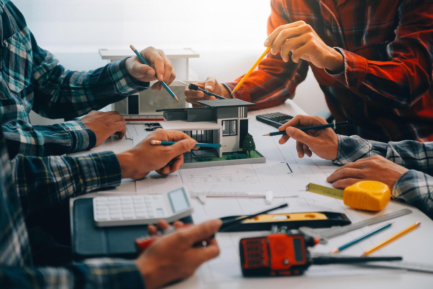 engineer people meeting working and pointing at a drawings in office for discussing. Engineering tools and construction concept. photo