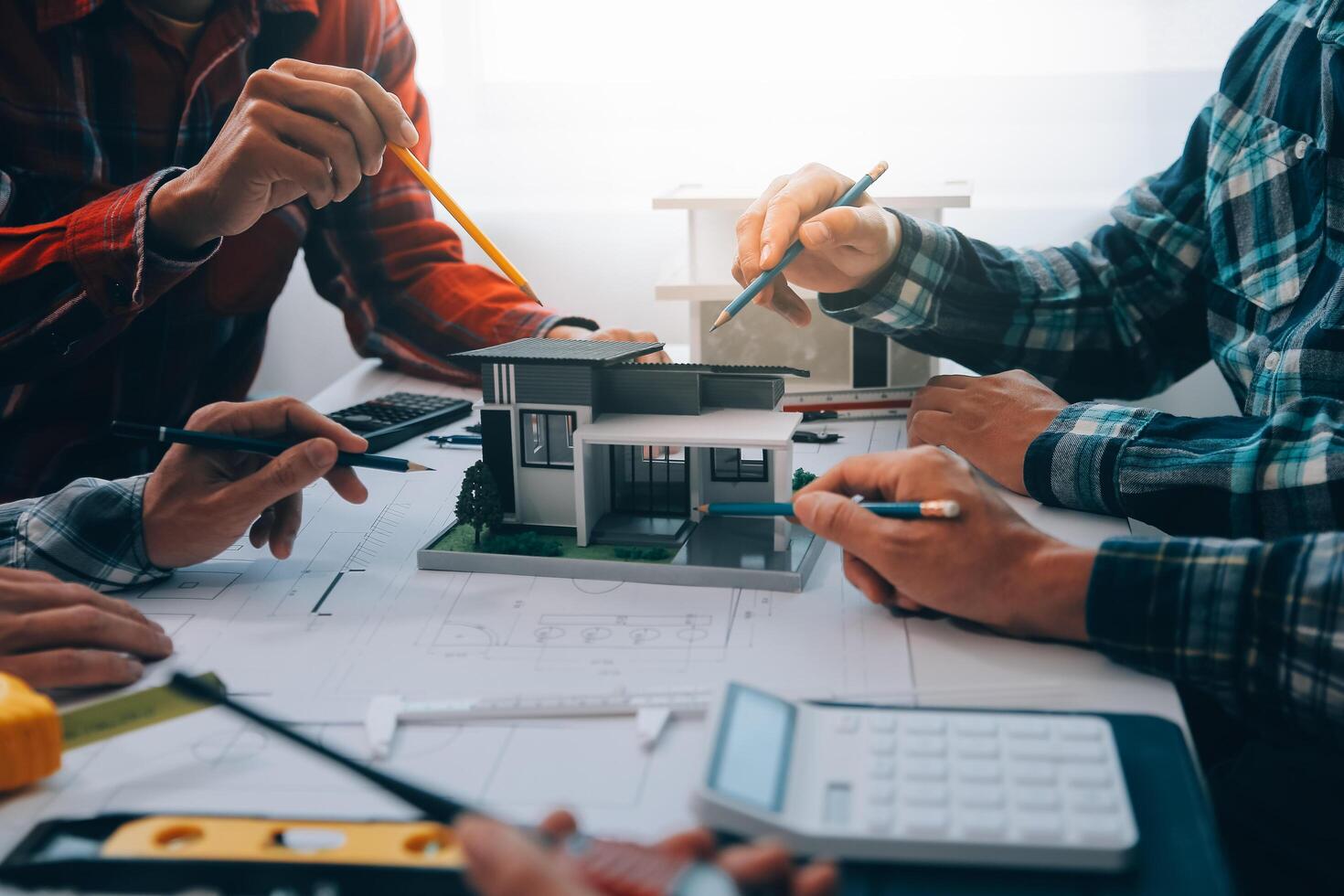 engineer people meeting working and pointing at a drawings in office for discussing. Engineering tools and construction concept. photo