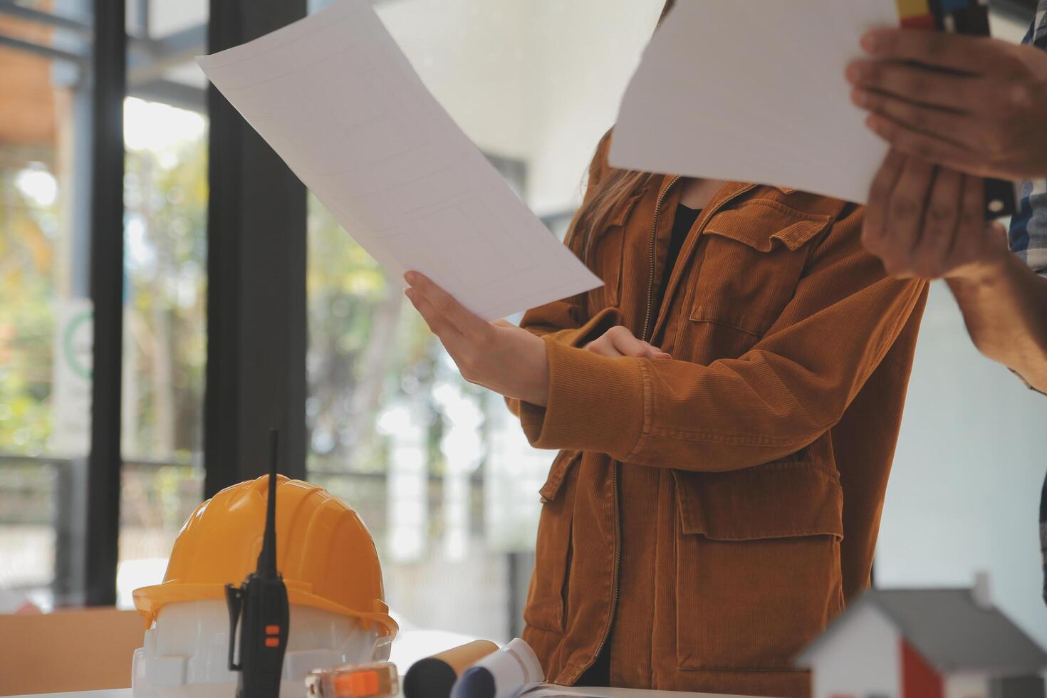 masculino y hembra industrial ingenieros en difícil sombreros discutir nuevo proyecto mientras utilizando ordenador portátil. ellos hacer demostración gestos ellos trabajo en un pesado industria fabricación fábrica. foto