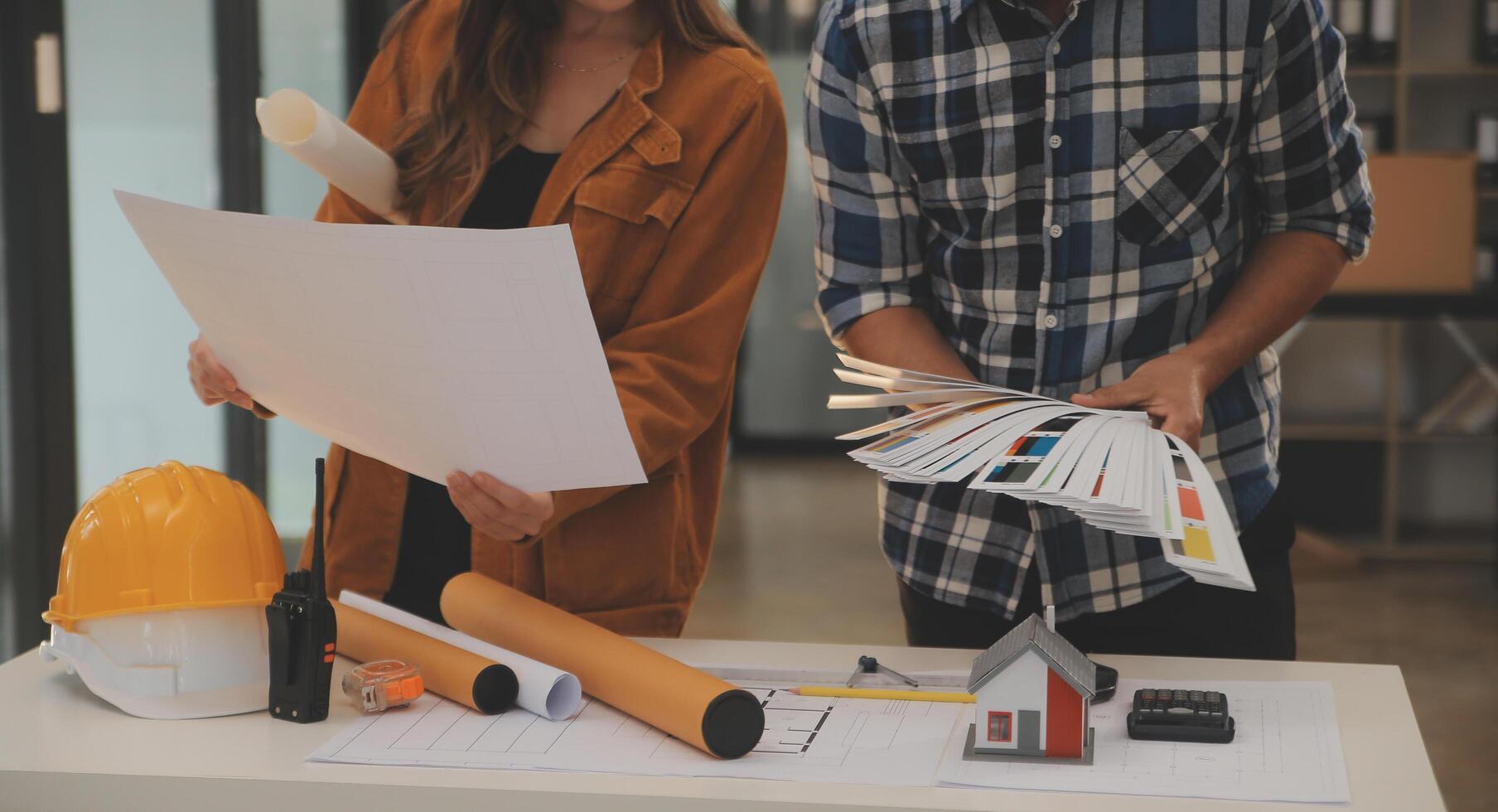 Male and Female Industrial Engineers in Hard Hats Discuss New Project while Using Laptop. They Make Showing Gestures.They Work in a Heavy Industry Manufacturing Factory. photo